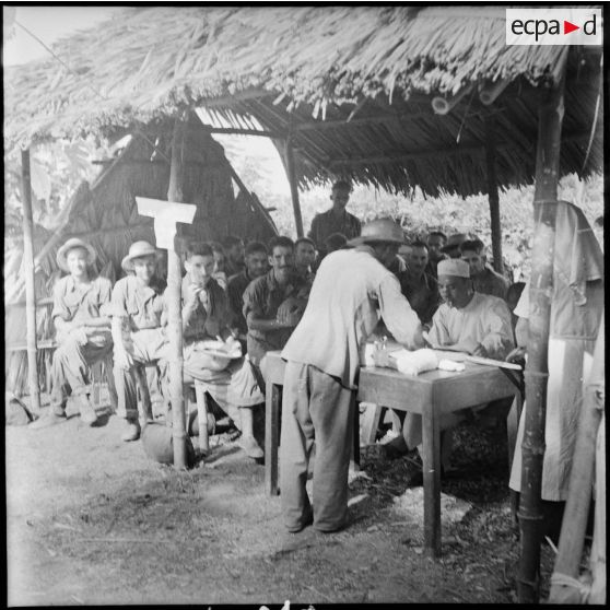 Avant leur libération, des prisonniers de guerre des forces de l'Union française passent par groupe de vingt personnes devant une commission médicale de l'Armée populaire vietnamienne.