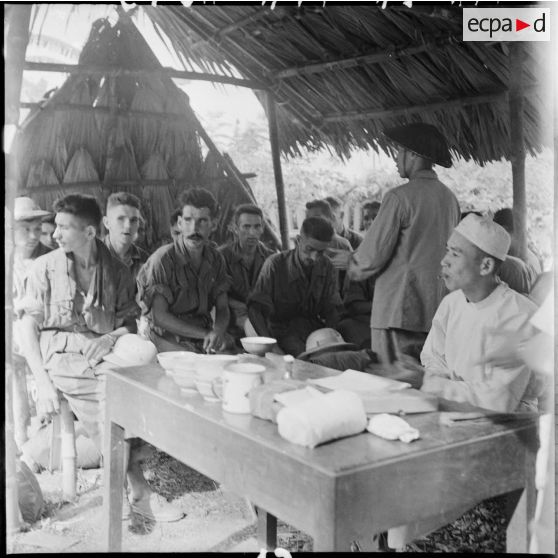 Avant leur libération, des prisonniers de guerre des forces de l'Union française passent par groupe de vingt personnes devant une commission médicale de l'Armée populaire vietnamienne.