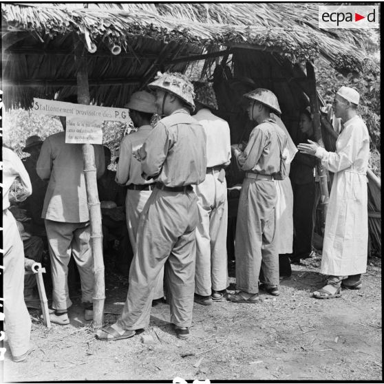 Soldats et équipe médicale de l'Armée populaire vietnamienne entonnent des chants à la gloire d'Ho Chi Minh avec les prisonniers des troupes de l'Union française avant leur libération.