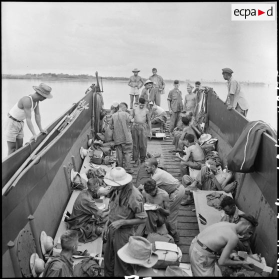 Prisonniers de guerre de l'Union française libérés par l'Armée populaire vietnamienne installés dans la cuve d'un bâtiment de débarquement au cours de leur rapatriement vers Hanoï.