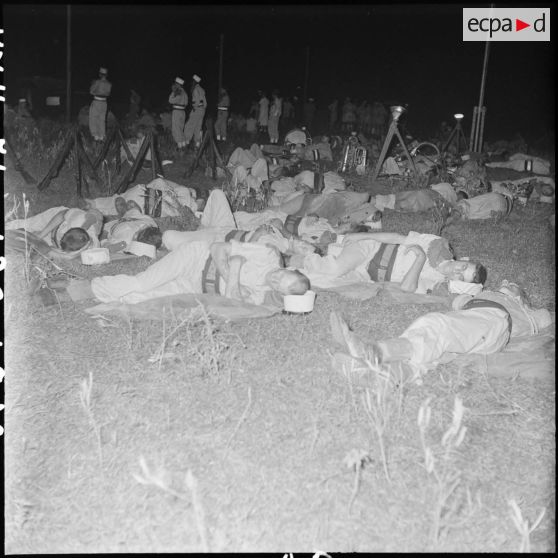 Des légionnaires dorment au sol en attendant l'arrivée de nuit de prisonniers libérés par le Vietminh à Viet Tri.