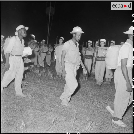 Des prisonniers de l'Union française libérés par le Vietminh à Viet Tri débarquent de nuit d'un chaland et sont accueillis par une compagnie de la Légion étrangère.