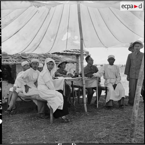 Des responsables vietminh et infirmières installés sous une tente lors de la libération de prisonniers de l'Union française à Viet tri.