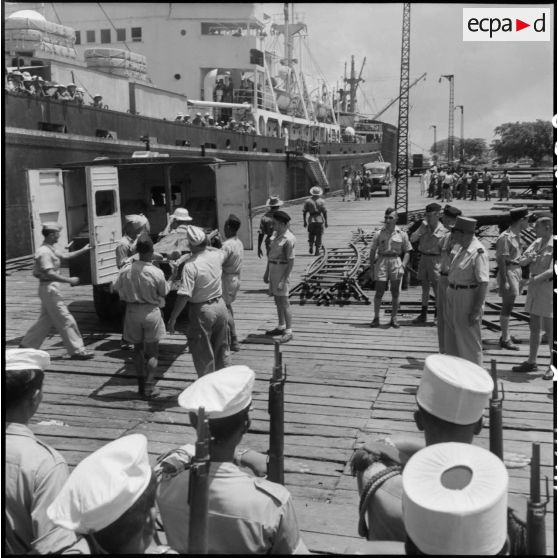 Sur le port d'Haïphong, certains prisonniers libérés par le Vietminh sont placés dans des ambulances pour être dirigés sur vers un hôpital.