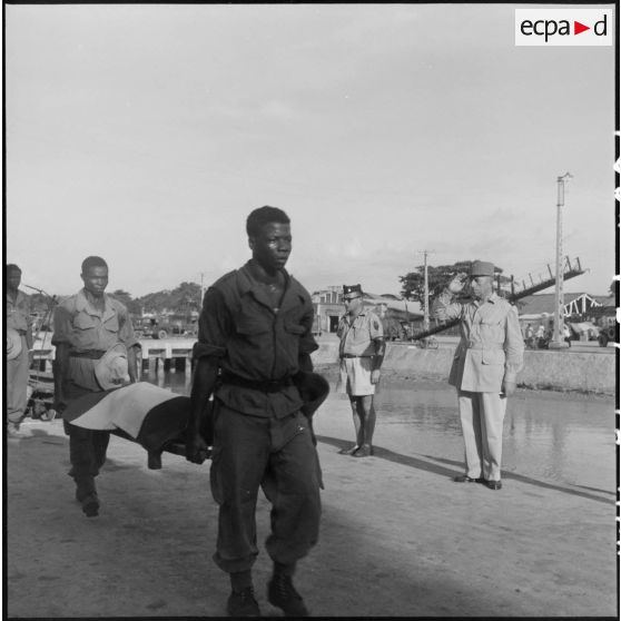 Transport de la dépouille d'un prisonnier libéré par le Vietminh décédé pendant son rapatriement par bateau à Haïphong.