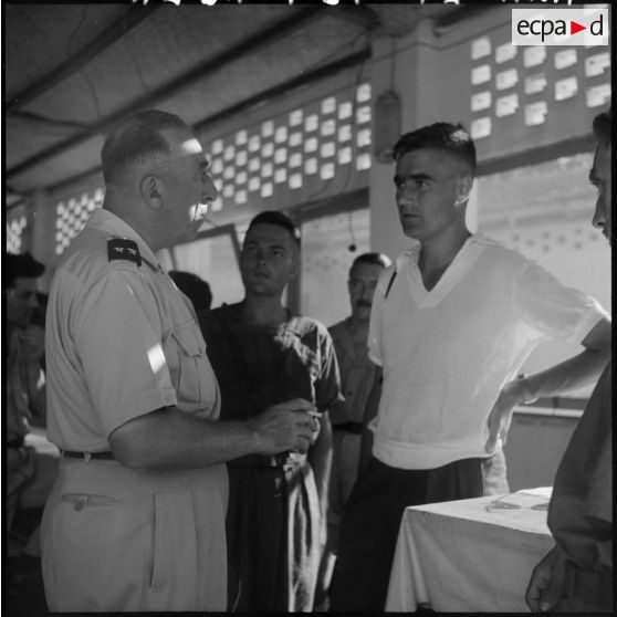 Entretien entre le général Franchi et Daniel Camus, photographe du Service presse information, lors de l'arrivée de prisonniers libérés par le Vietminh à Haïphong.