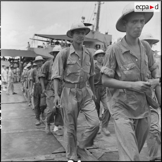 Des prisonniers libérés par le Vietminh débarquent d'un chaland de débarquement sur les quais d'Haïphong.