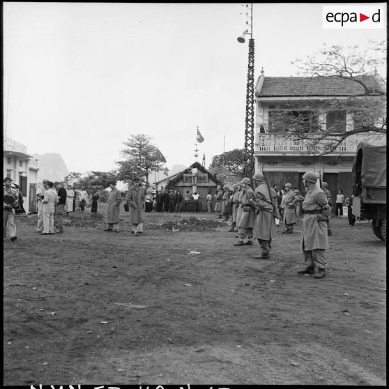 La police militaire et des journalistes sont postés au carrefour de Campha quelques instants avant l'arrivée des troupes vietminh dans la ville.