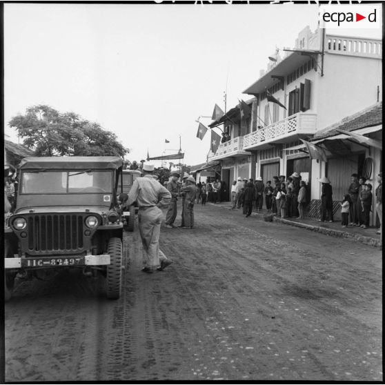 Dernières consignes données par les Français aux officiers de l'Armée populaire vietnamienne dans les rues de Campha pavoisées aux couleurs vietminh.