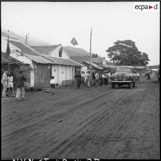 Précédées de la Commission internationale de contrôle les troupes vietminh entrent dans Campha sous le regard de la population.