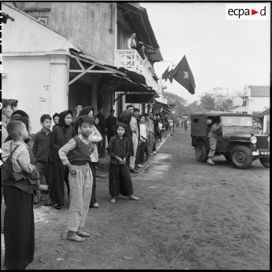 Peu enthousiaste, la population assiste à l'entrée des troupes vietminh dans Campha.