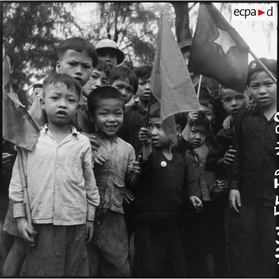 Groupe d'enfants munis de drapeaux accueillant les troupes vietminh à Hongay.