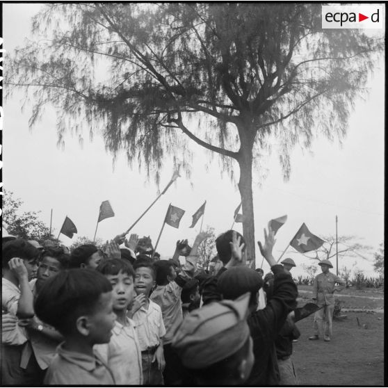 Groupe d'enfants munis de drapeaux accueillant les troupes vietminh à Hongay.