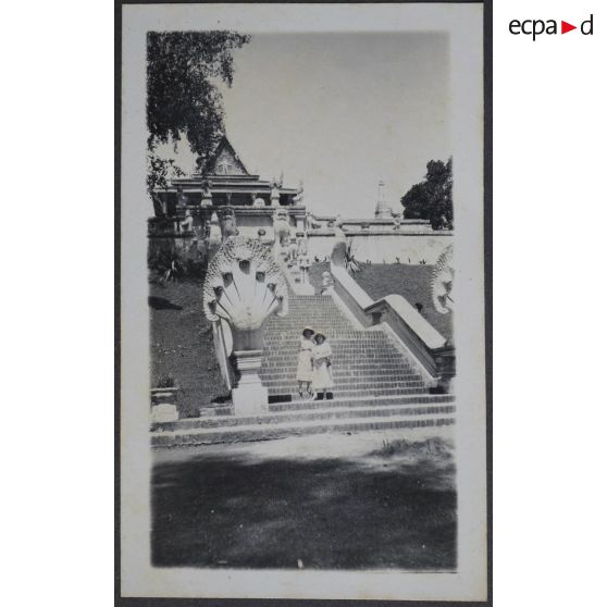 [Phnom Penh. Deux femmes devant des escaliers menant à un temple].