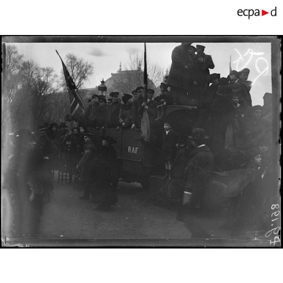 Paris. Visite du roi et de la reine des Belges. Spectateurs perchés sur un camion avenue des Champs-Elysées. [légende d'origine]