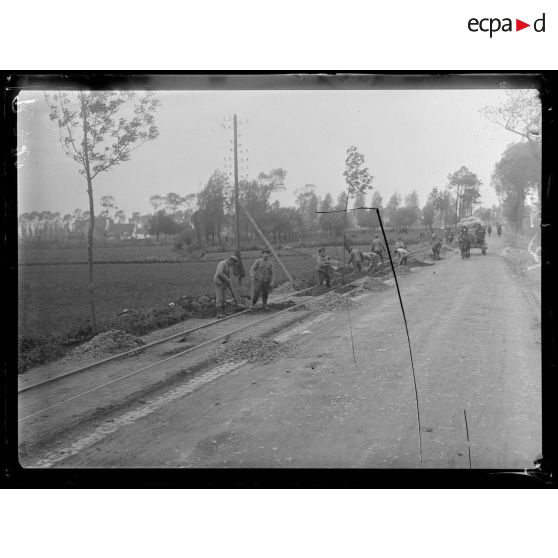 Près de Furnes (Belgique). Soldats belges construisant une ligne ferrée à voie étroite sur la route de Furnes à Ypres. [légende d'origine]