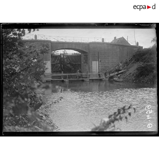 [Des soldats se tiennent sur une passerelle qui longe un pont.]