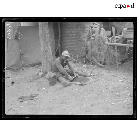 Bois d'Houssoy, près de Remaugis (Somme). Camp de tirailleurs sénégalais, 62e bataillon, soldat écrasant du café. [légende d'origine]