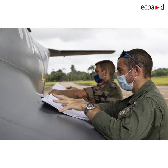 Le pilote d'un avion Casa Cn-235 effectue des formalités administratives avec un marsouin du 9e régiment d'infanterie de marine (9e RIMa) à son arrivée à Maripasoula, en Guyane française.