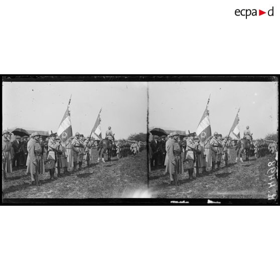 Montagne-Fayel (Somme), à l'escadrille des Cigognes, remise par le commandant Fécamp de la rosette d'officier de la légion d'honneur à l'aviateur Garros, et de la Croix de Chevalier à l'aviateur Marchal. Le drapeau de l'aviation tenu par le sous-lieutenant Fonck et le drapeau de l'aérostation tenu par le lieutenant Botton. [légende d'origine]