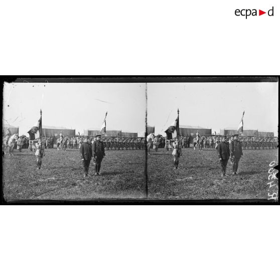 Montagne-Fayel (Somme), à l'escadrille des Cigognes, remise par le commandant Fécamp de la rosette d'officier de la légion d'honneur à l'aviateur Garros, et de la Croix de Chevalier à l'aviateur Marchal. Le drapeau de l'aviation tenu par le sous-lieutenant Fonck et le drapeau de l'aérostation tenu par le lieutenant Botton. [légende d'origine]