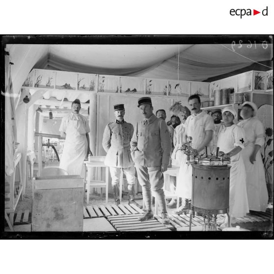 [Photographie de groupe rassemblant des autorités militaires et du personnel infirmier à l'intérieur d'un hôpital militaire souterrain.]