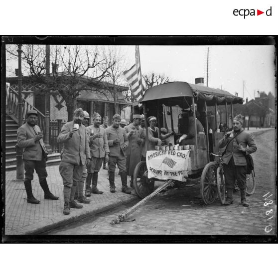 [Des soldats sont rassemblés devant une cantine américaine.]