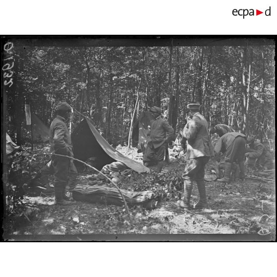 [Scène de la vie quotidienne dans un campement : des soldats italiens montent leurs tentes en pleine forêt, dans la Marne.]