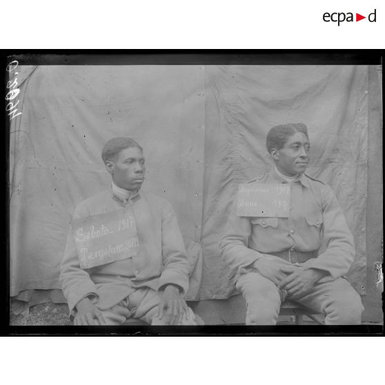 [Portrait de deux soldats qui portent sur le torse une pancarte comportant leur nom, leur classe, un lieu d'incorporation et un numéro matricule.]