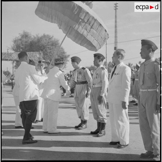 Remise de décorations par le roi du Cambodge Norodom Sihanouk au cours d'une cérémonie commémorant l'anniversaire de la rétrocession de Battambang par le Siam.