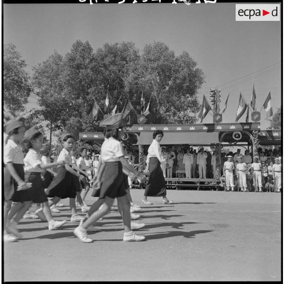 Défilé des écoliers devant la tribune officielle lors d'une cérémonie pour l'anniversaire de la rétrocession Battambang par le Siam.