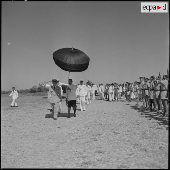 Le roi du Cambodge Norodom Sihanouk passe en revue les troupes venues lui rendre les honneurs sur le terrain d'aviation de Battambang.