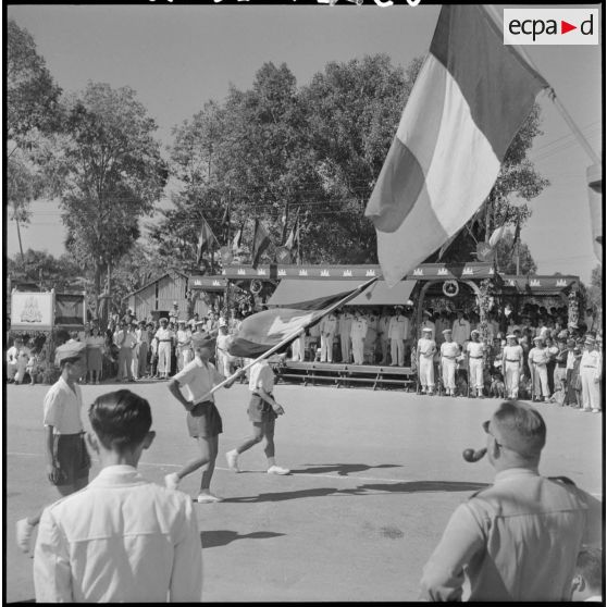 Défilé des écoliers devant la tribune officielle lors d'une cérémonie pour l'anniversaire de la rétrocession Battambang par le Siam.