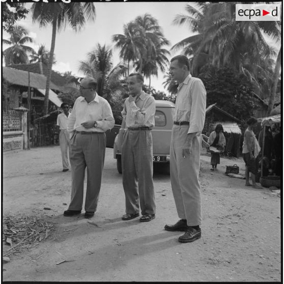 Le directeur du service de l'information américain, Jean Barré et l'adjoint du commissaire de Battambang, lors d'une halte dans un village.