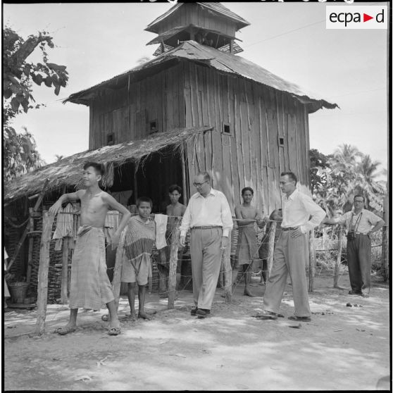 Le directeur du service de l'information américain, Jean Barré et l'adjoint du commissaire de Battambang, lors d'une halte dans un village.