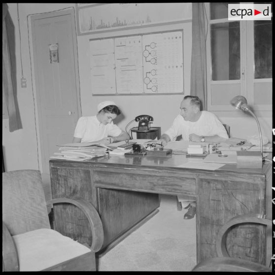 Le médecin-colonel Petchot Bacque dicte et l'infirmière Christiane Sacquet travaillant dans un bureau.