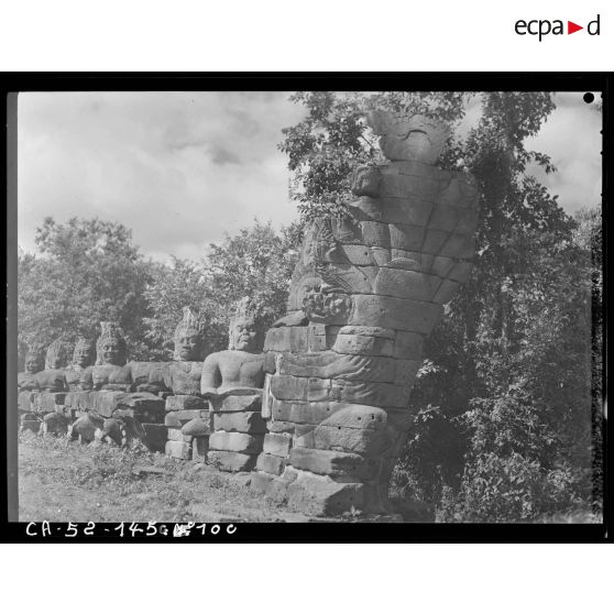 Naga à sept têtes étreint par des démons (ou Yaksas) en bordure de la chaussée menant à la porte Nord d'Angkor Thom.