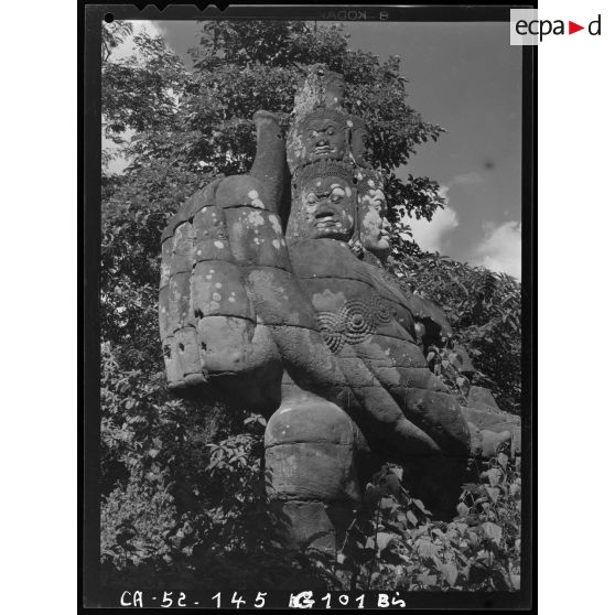 Géant polycéphale et à bras multiples étreignant la queue du Naga, formant balustrade devant la porte dite des Morts de l'enceinte Est du Bayon.