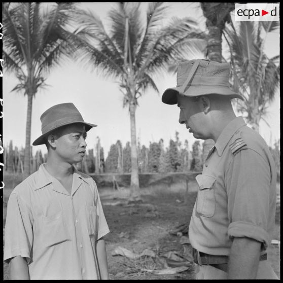 Le capitaine commandant une cie du 5e bataillon de chasseurs cambodgiens (5e BCC) s'entretient avec un planteur dans la région de Kampot.