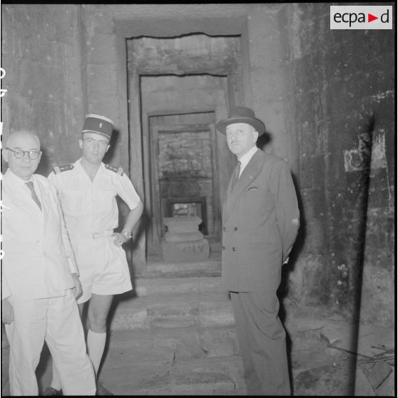 Le ministre de l'Education nationale M. Berthoin dans une galerie d'Angkor Vat en compagnie de M. Malleret, directeur de l'Ecole française d'Extrême-Orient (EFEO).