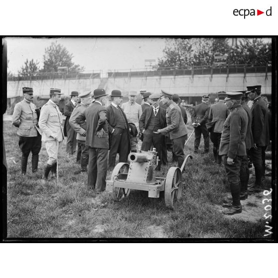 Présentation d'un canon de 75mm de tranchée aux parlementaires russes en visite aux usines Schneider. [légende d'origine]