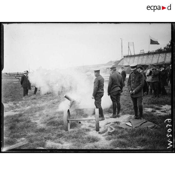 Présentation d'un canon de 75mm de tranchée aux parlementaires russes en visite aux usines Schneider. [légende d'origine]