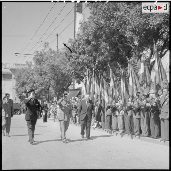 Accompagné du président de l'association des anciens combattants (AC), le général Gilles salue leur drapeau.