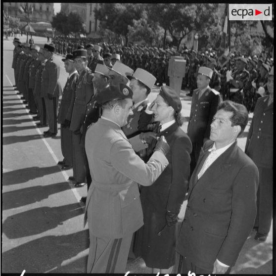 Une femme de la 103ème section d'infirmiers militaires (SIM), est décorée par le général Gilles de la médaille militaire.