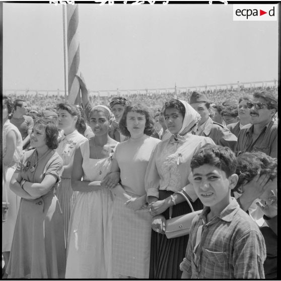 Jeunes filles parmi la foule au stade d'Oran pour la venue du général Salan, du général Massu et de Jacques Soustelle.