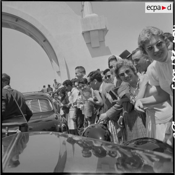 La foule applaudit les autorités qui sortent du stade d'Oran en voiture.