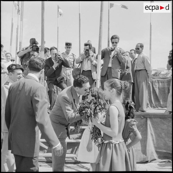 Biskra. Trois fillettes remettent un bouquet de fleurs à Jacques Soustelle.