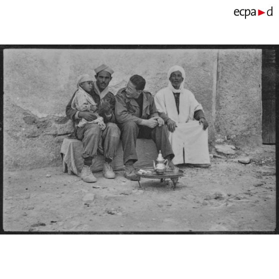 Soldat prenant le thé avec deux hommes et un enfant.