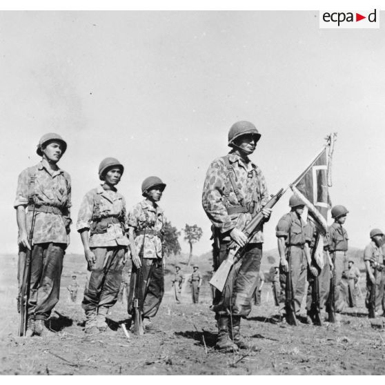 Lors d'une prise d'armes à Na San, le chef de bataillon Bonnigal, commandant le 3e bataillon de parachutistes coloniaux (3e BPC) porte le fanion de son unité.