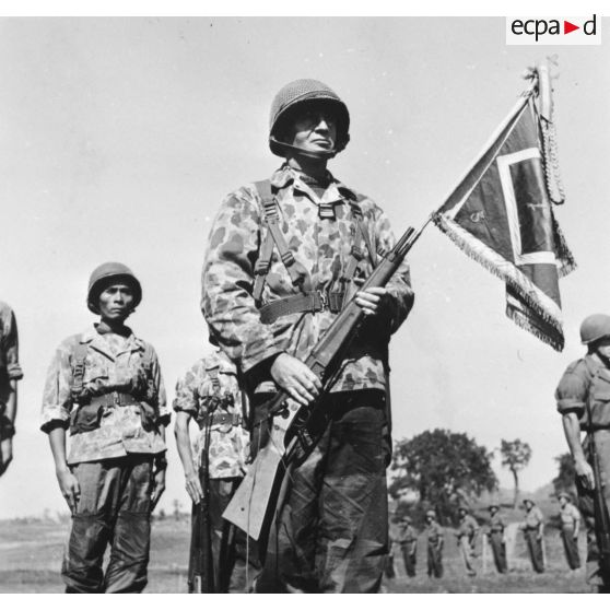 Lors d'une prise d'armes à Na San, le chef de bataillon Bonnigal, commandant le 3e bataillon de parachutistes coloniaux (BPC) et le fanion de son unité.